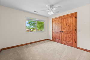 Unfurnished bedroom with carpet flooring and a ceiling fan