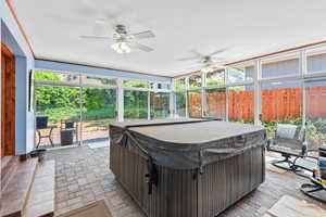Sunroom featuring a hot tub and ceiling fan