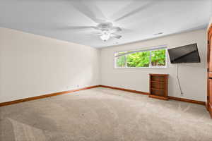 Spare room featuring light colored carpet and a ceiling fan
