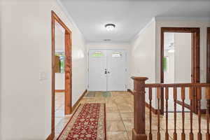 Foyer entrance with baseboards and ornamental molding