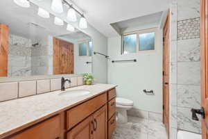 Full bath featuring marble finish flooring and vanity
