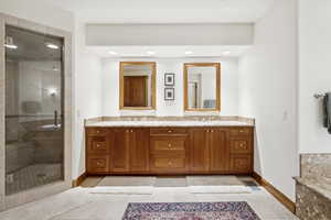 Bathroom featuring double vanity, a stall shower, and recessed lighting