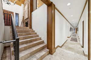 Stairs with stone tile floors, recessed lighting, and a chandelier