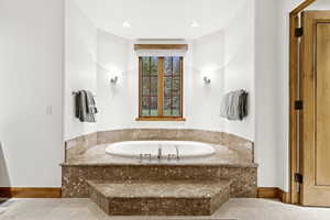 Bathroom with baseboards and a bath