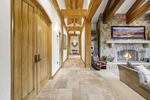 Hall with stone tile floors and beamed ceiling