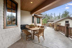 View of patio with outdoor dining area and grilling area