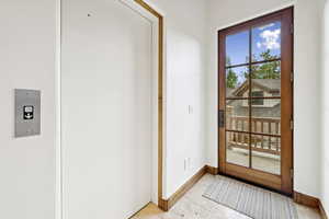 Doorway to outside featuring baseboards