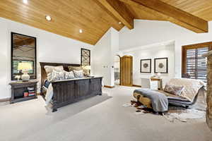 Bedroom featuring carpet flooring, arched walkways, a wood ceiling with exposed beams, recessed lighting, and high vaulted ceiling