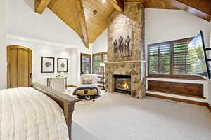 Bedroom with carpet, multiple windows, high vaulted ceiling, a fireplace, and a wooden ceiling with exposed beams