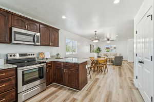 Kitchen featuring appliances with stainless steel finishes, light wood-style flooring, plenty of natural light, a peninsula, and recessed lighting