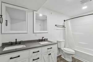 Bathroom featuring double vanity, wood finished floors, and shower / tub combo with curtain