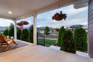 Covered porch featuring a mountain view and a yard