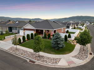 View of front of property featuring an attached garage, a mountain view, a residential view, covered porch, and concrete driveway