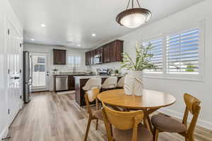 Dining area with light wood-type flooring and recessed lighting