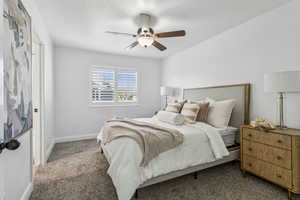 Carpeted bedroom featuring baseboards and a ceiling fan