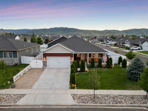 Ranch-style house featuring a gate, an attached garage, a residential view, and a mountain view