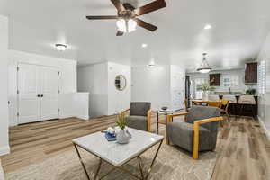 Living area with light wood finished floors, ceiling fan, and recessed lighting