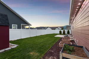 Fenced backyard featuring a garden