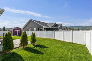 Fenced backyard with a shed and a patio area