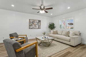 Living room with light wood finished floors, ceiling fan, and recessed lighting