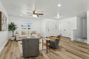 Living room featuring ceiling fan, light wood-type flooring, and recessed lighting
