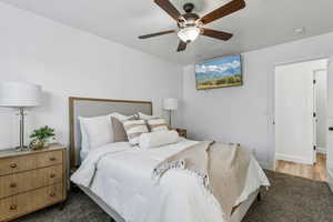 Carpeted bedroom featuring baseboards and ceiling fan