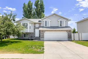 View of front of home featuring an attached garage, driveway, brick siding, and roof with shingles