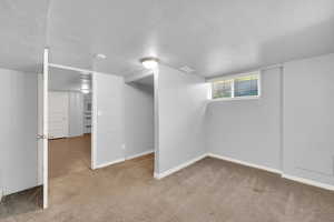 Below grade area featuring carpet and a textured ceiling