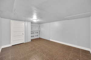 Finished below grade area with baseboards and a textured ceiling