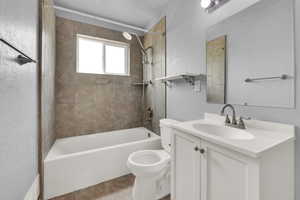 Full bath featuring bathtub / shower combination, vanity, tile patterned flooring, and a textured wall