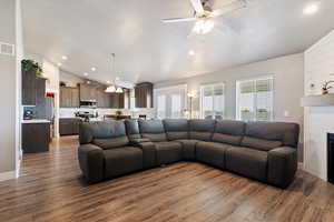 Living room with vaulted ceiling, ceiling fan, wood finished floors, recessed lighting, and a large fireplace