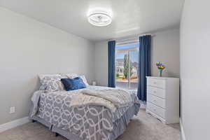 Bedroom featuring light colored carpet and baseboards