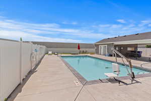 Community pool featuring a fenced backyard and a patio area