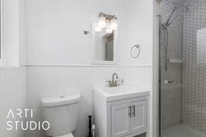 Bathroom with a stall shower, vanity, and wainscoting