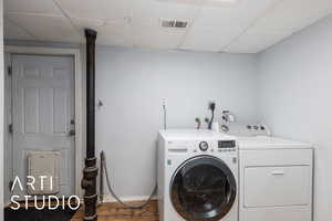 Laundry area with washing machine and clothes dryer and wood finished floors