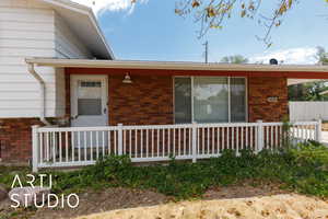 View of side of home with brick siding and a porch