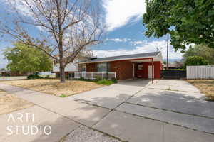 View of front of property featuring concrete driveway, brick siding, and an attached carport