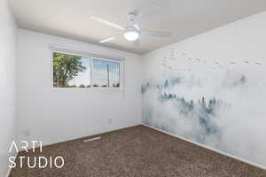 Carpeted spare room featuring a ceiling fan and baseboards