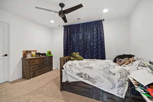 Carpeted bedroom featuring recessed lighting and a ceiling fan