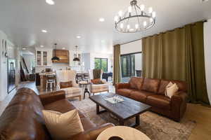 Living area with a chandelier, light wood-style flooring, and recessed lighting