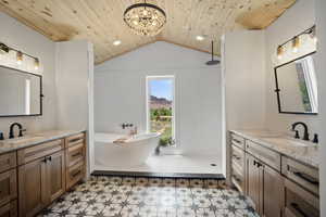 Full bath with tile patterned floors, wooden ceiling, walk in shower, vaulted ceiling, and two vanities