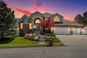 View of front of home featuring concrete driveway, a yard, brick siding, a shingled roof, and a garage