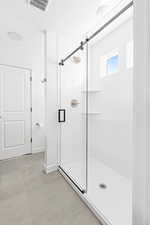 Bathroom featuring a shower stall and tile patterned flooring