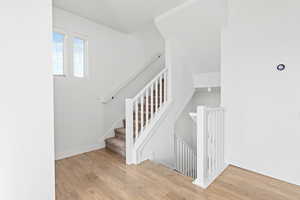 Stairway with hardwood / wood-style flooring and baseboards