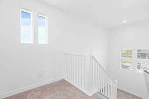 Stairs with carpet and recessed lighting