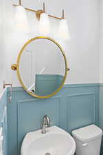 Bathroom with a decorative wall and a wainscoted wall
