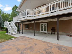 Rear view of property with french doors, a patio area, a wooden deck, and stairs