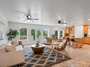 Living room with ceiling fan, healthy amount of natural light, light tile patterned floors, recessed lighting, and french doors