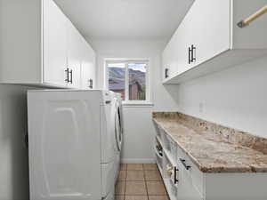 Washroom featuring washing machine and dryer and cabinet space