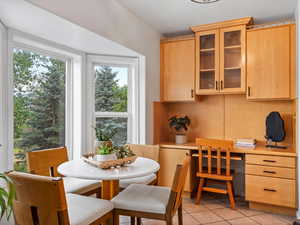 Dining room with light tile patterned floors and built in study area